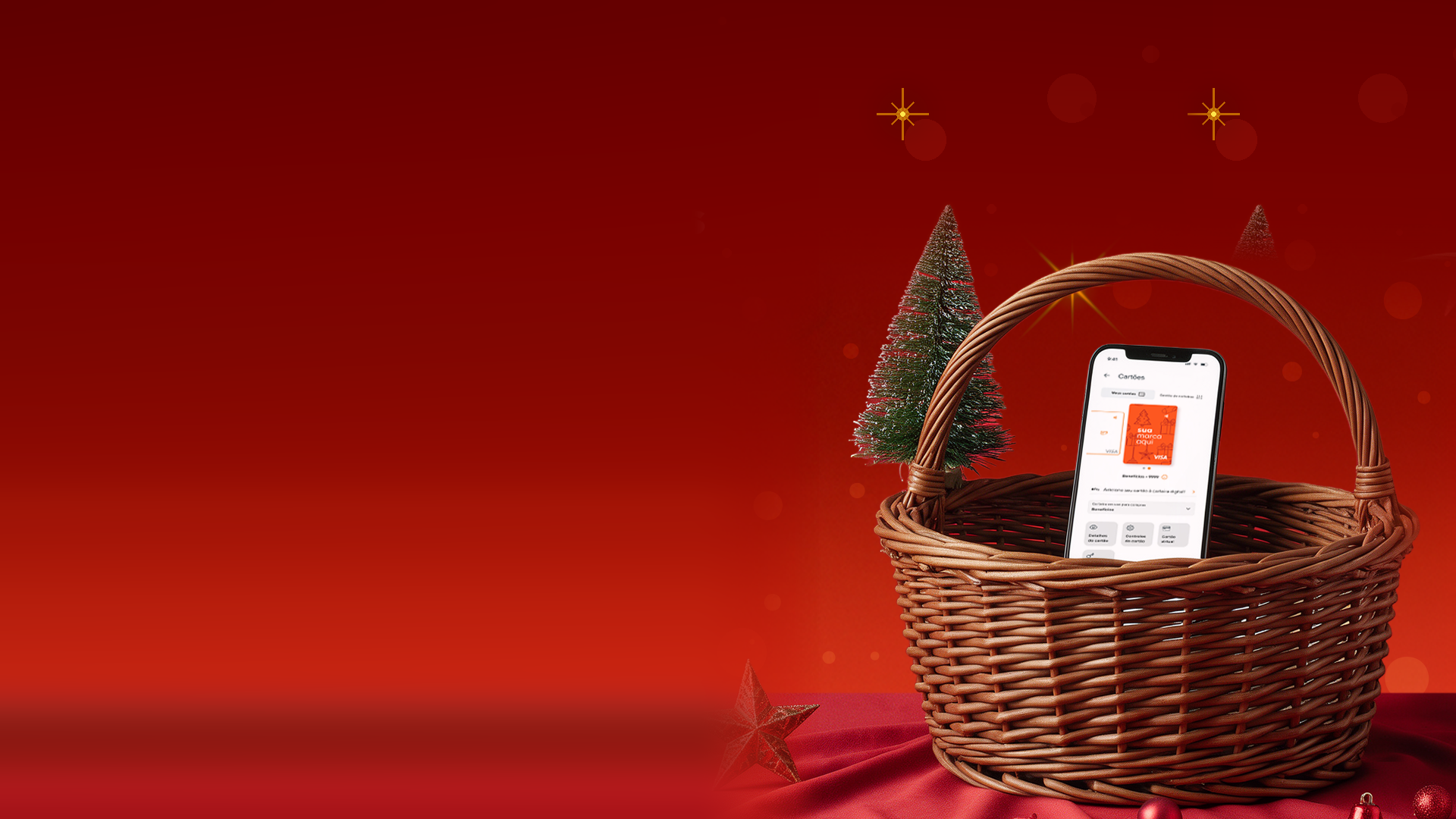 Cesta de Natal, ao lado de um celular com aplicativo de benefícios aberto.